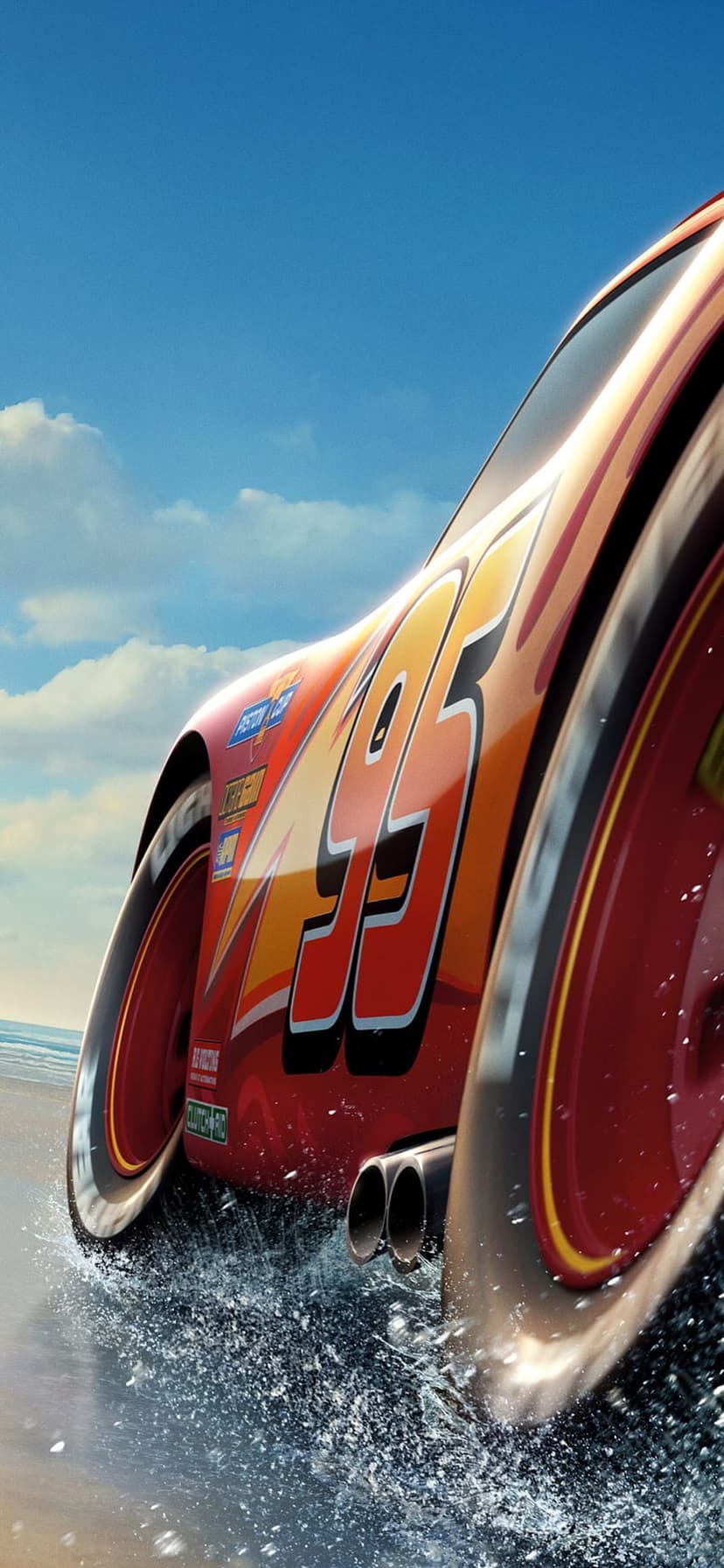 Lightning McQueen speeds across a wet racetrack with water splashing from tires under a bright blue cloudy sky.