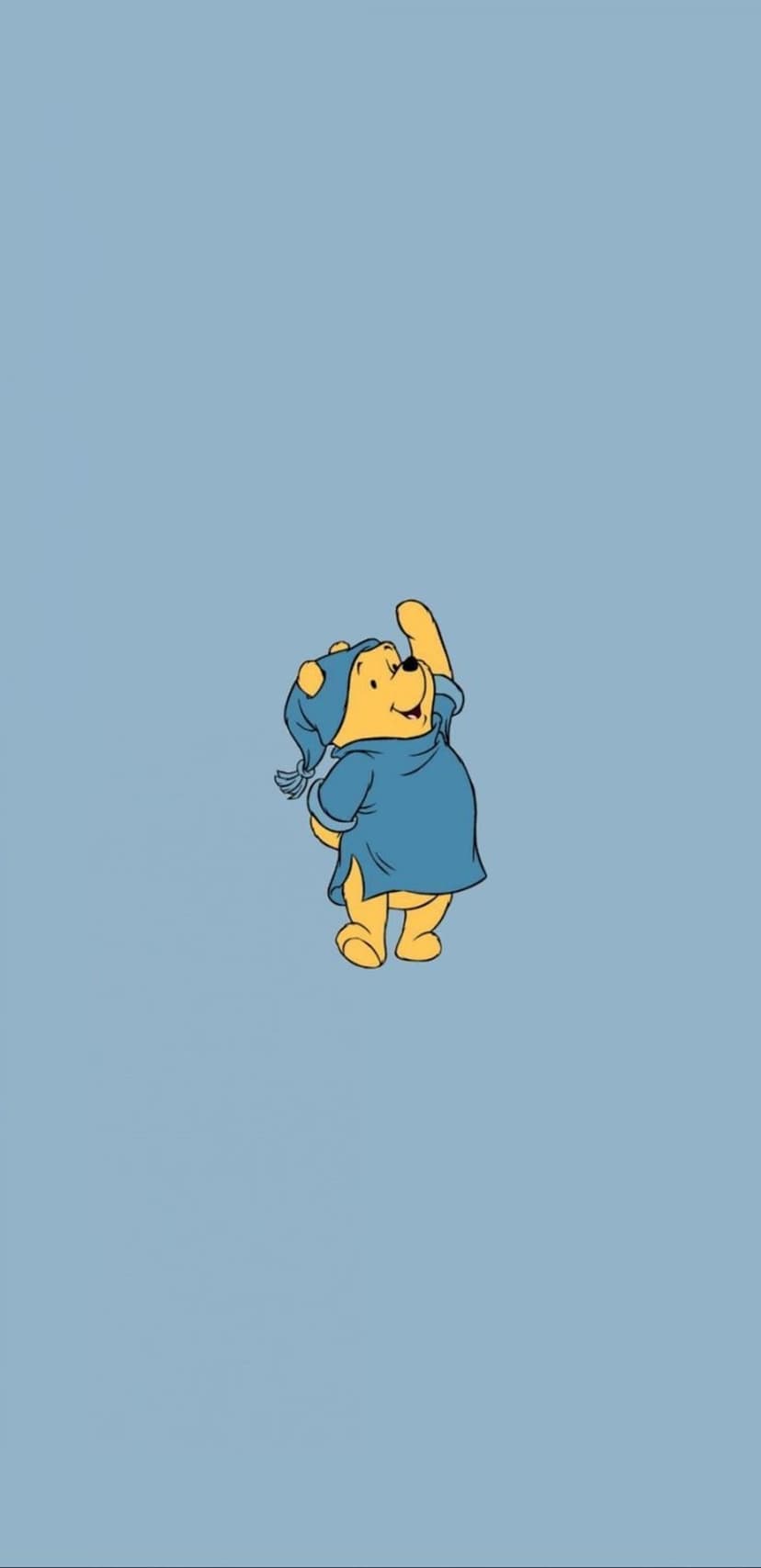 Winnie the Pooh wears a blue nightshirt and matching cap while waving against a light blue background.
