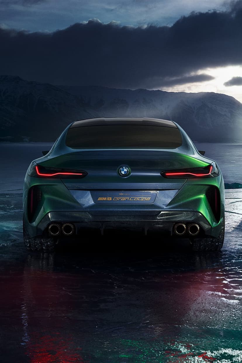 BMW M8 Gran Coupe Concept rear showing red LED taillights, quad exhausts, and green paint against mountain peaks.