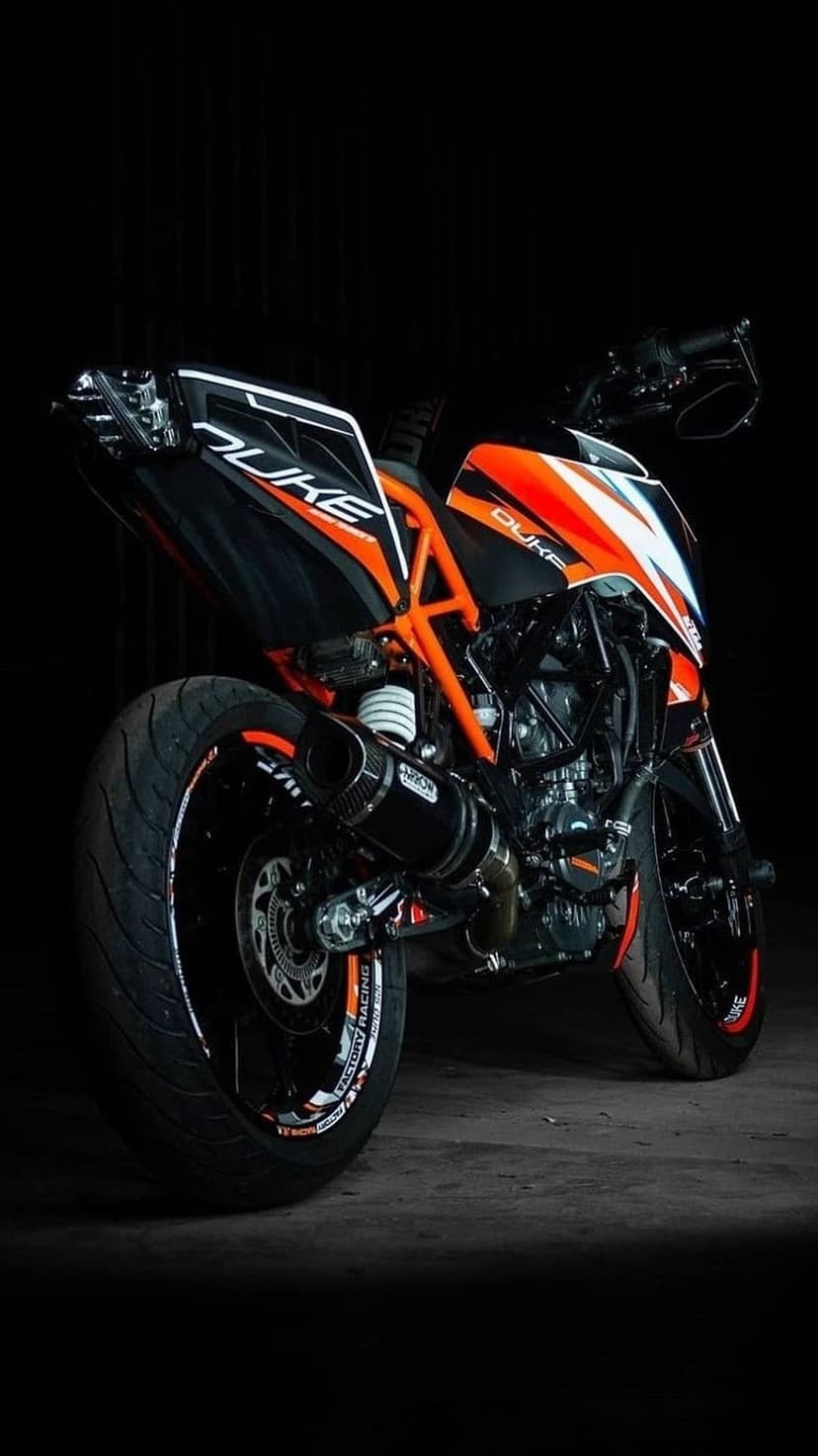 KTM Duke sports motorcycle features a vibrant orange frame and detailed rear wheel in a close-up profile view.