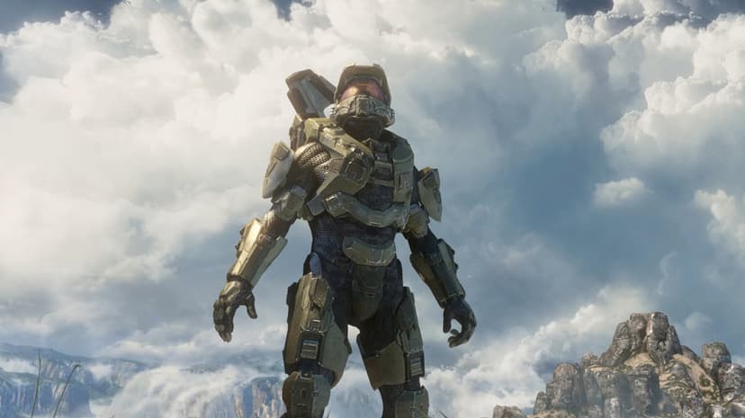 Master Chief in green armor stands looking up at a vast sky filled with bright, towering white clouds.