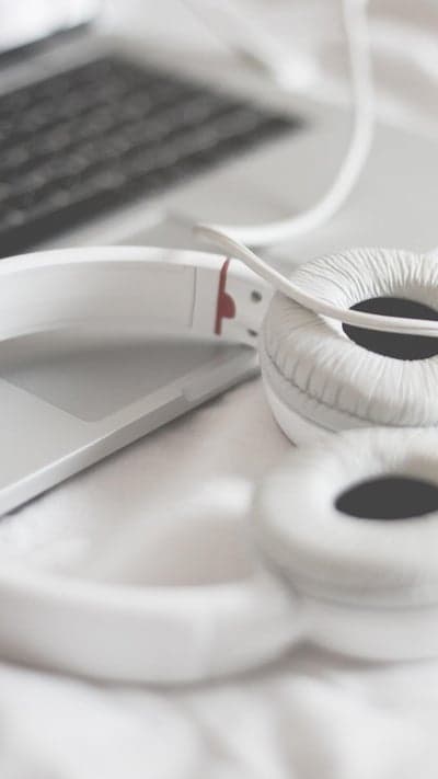 White Headphones Resting on Laptop Keyboard