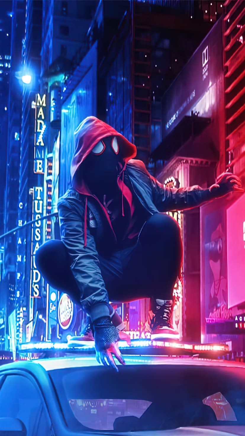 Miles Morales in a red-hooded suit crouches on a police car roof amid glowing blue and red neon skyscrapers.