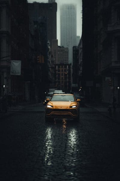 Yellow Lamborghini on Wet City Street at Dusk