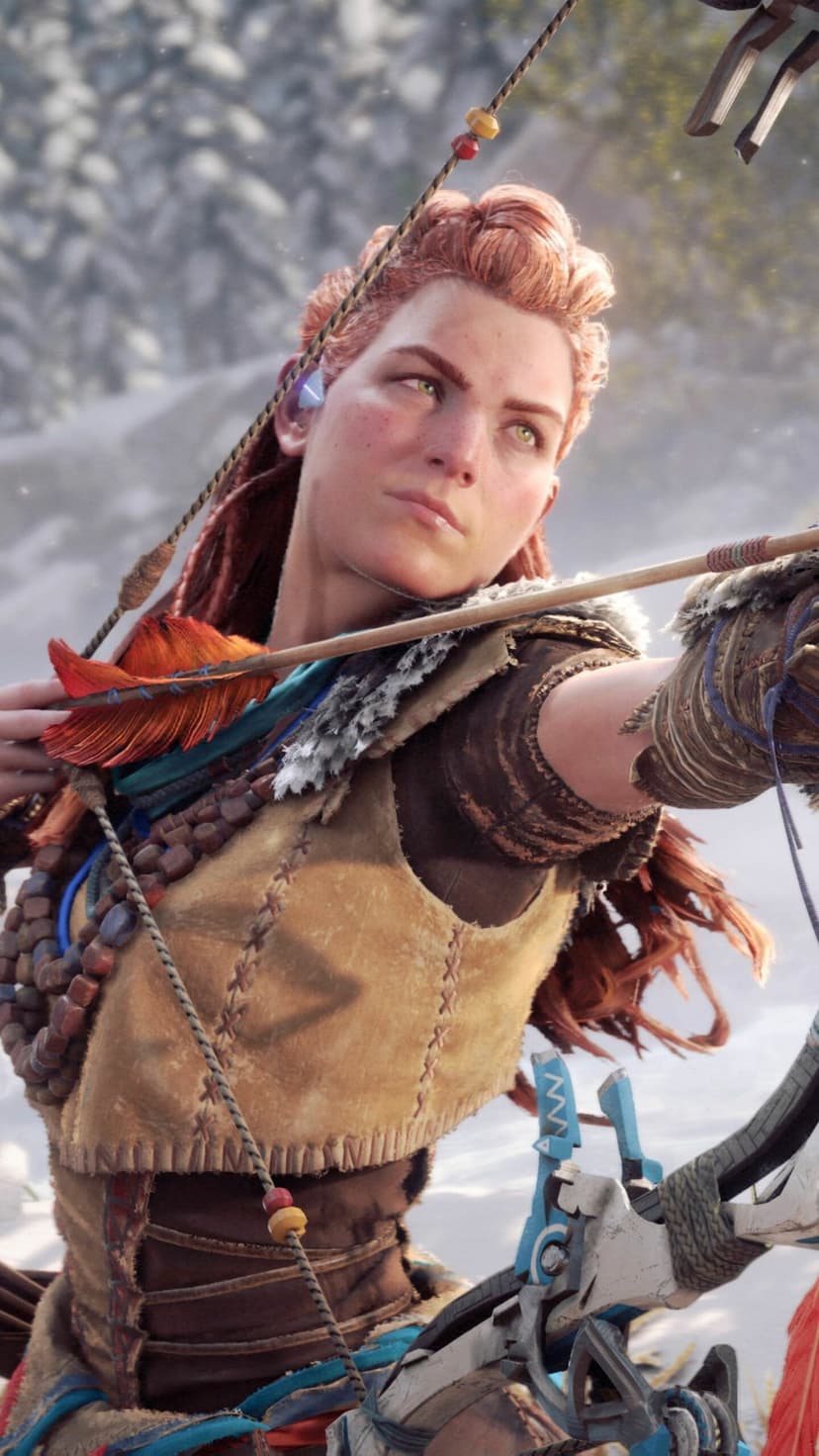 Aloy aiming a bow with an orange feathered arrow against a blurred snowy mountain background in portrait view.