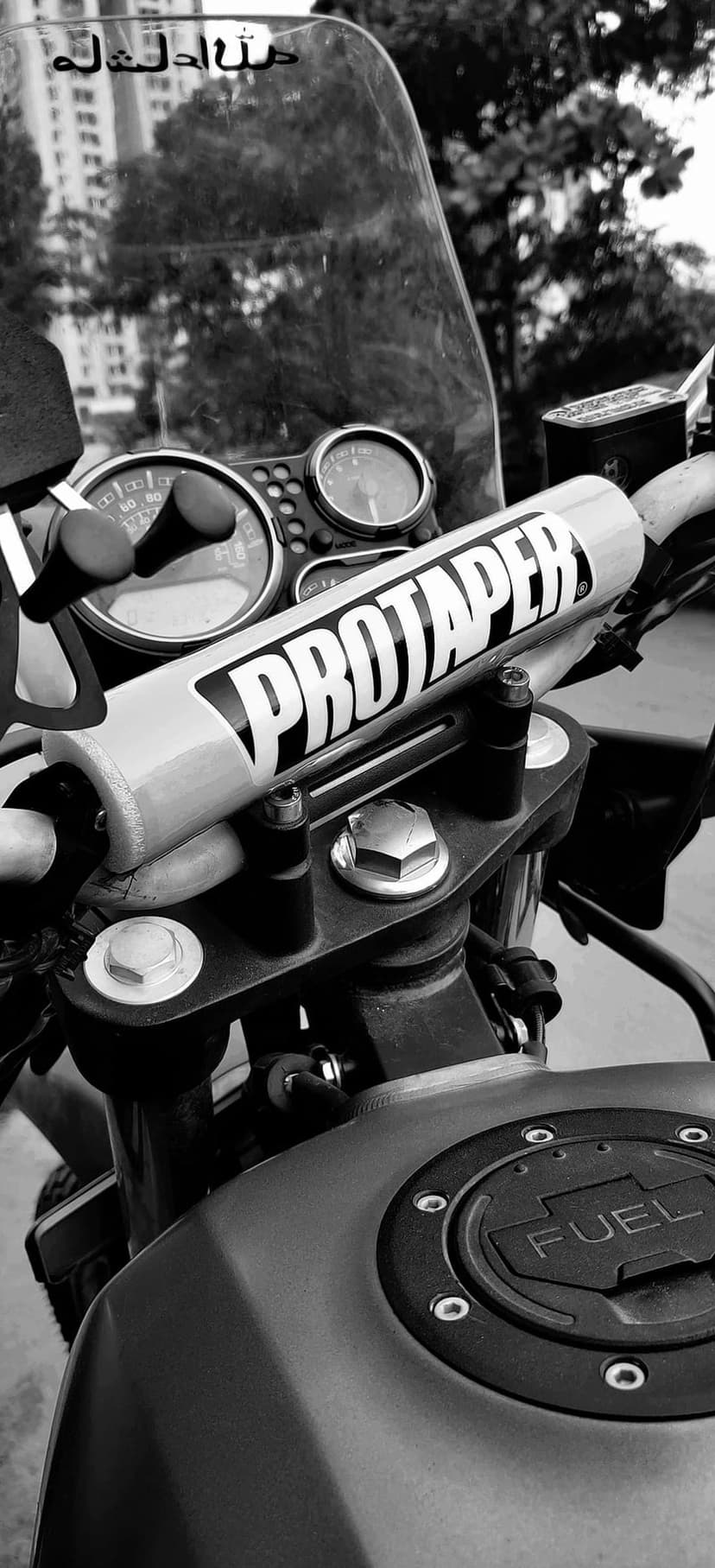 ProTaper motorcycle handlebars and fuel tank cap captured in a high-contrast black and white close-up photography.