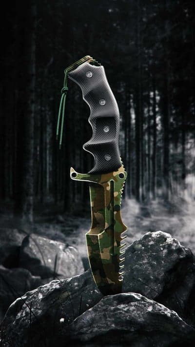 Camouflage Survival Knife Standing on Rocks in Forest