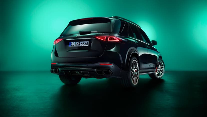 Rear view of a black Mercedes-AMG GLE 63 S SUV with red LED taillights against a glowing teal studio background.