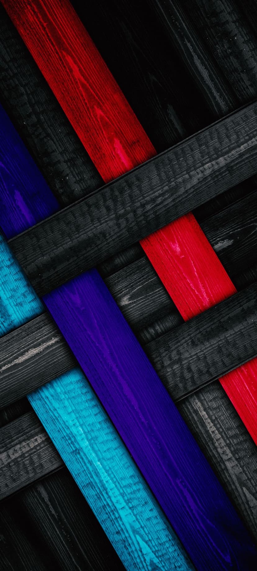 Red, blue, and black wooden planks arranged diagonally with visible grain textures and weathered finishes.