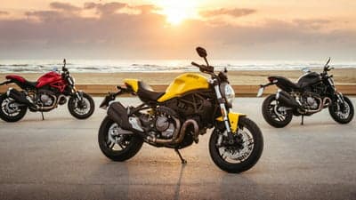 Three Ducati Monster Motorcycles on Beach Sunset Background