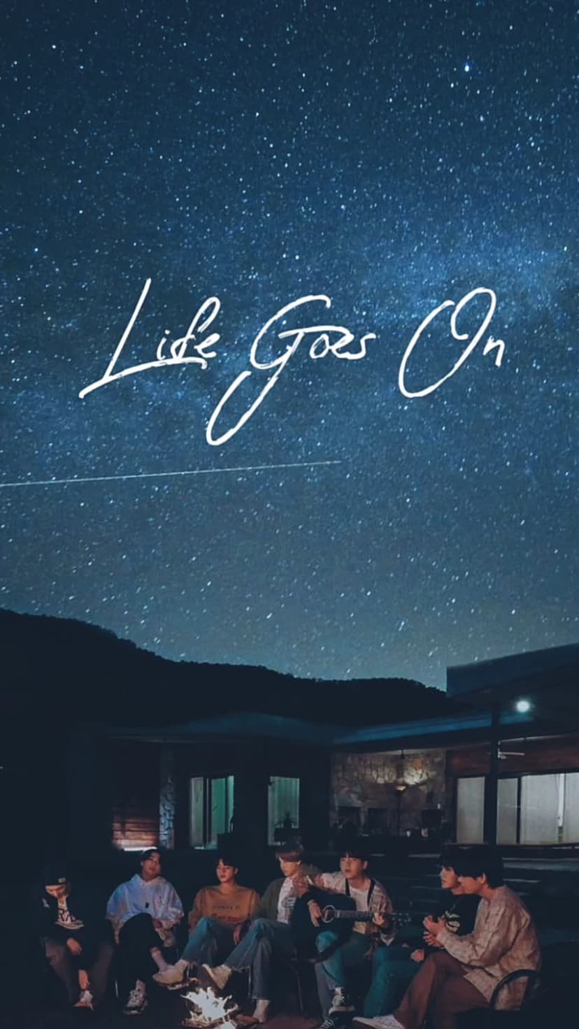 BTS members sit around a glowing campfire under a starry night sky with script text reading Life Goes On.