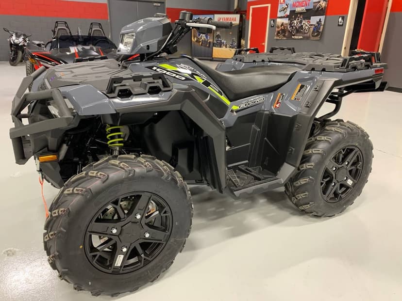 Polaris Sportsman 1000 XP ATV in matte grey with lime green accents showcased on a polished showroom floor.