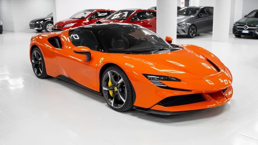 Orange Ferrari SF90 Stradale supercar with a black roof and yellow calipers in a bright white showroom.