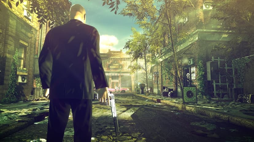 Agent 47 in a black suit holding a suppressed pistol in a sunlit, gritty alleyway with brick buildings.