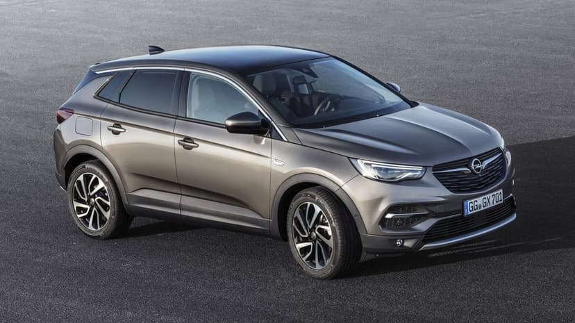 Bronze Opel Grandland X SUV parked on asphalt with a black roof and silver alloy wheels in high angle view.