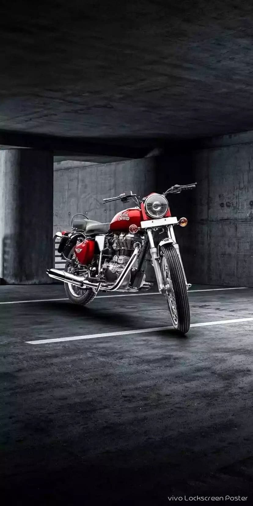 Red Royal Enfield motorcycle in a dark industrial garage featuring chrome engine details and concrete floors.