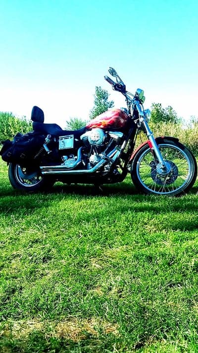 Red Motorcycle Parked on Green Grass with Blue Sky