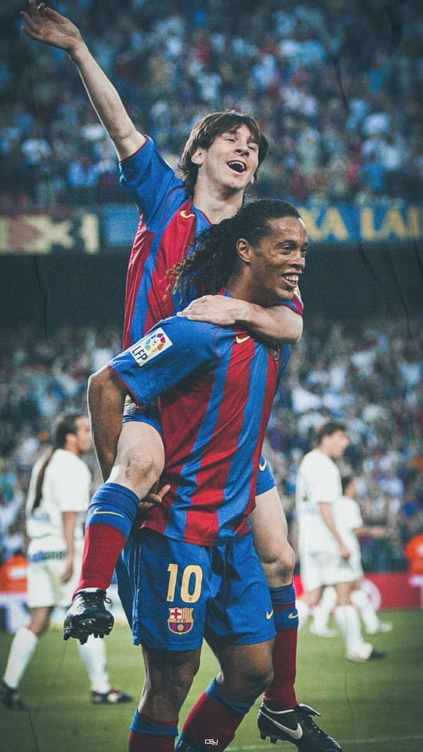 Ronaldinho carries young Lionel Messi on his back while wearing red and blue striped Barcelona soccer jerseys.