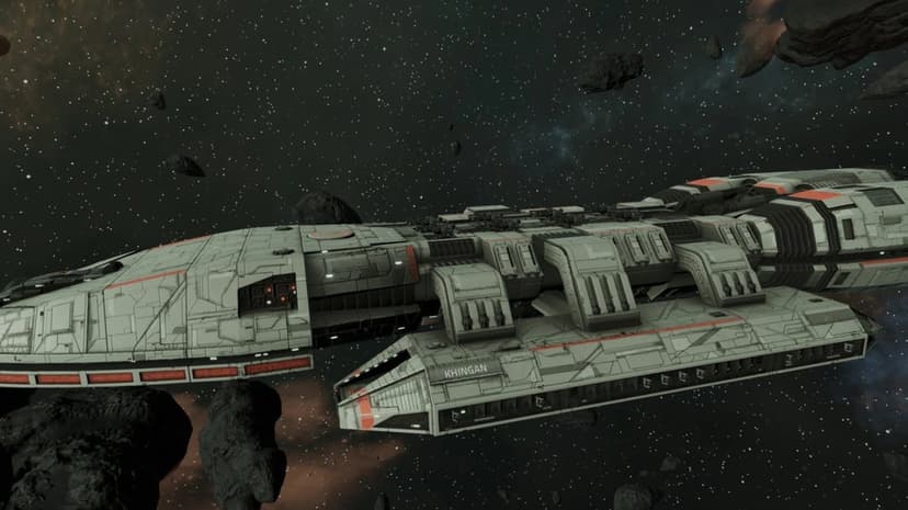Large grey spaceship named Khingan with red accents navigates through a dark asteroid field in deep space.