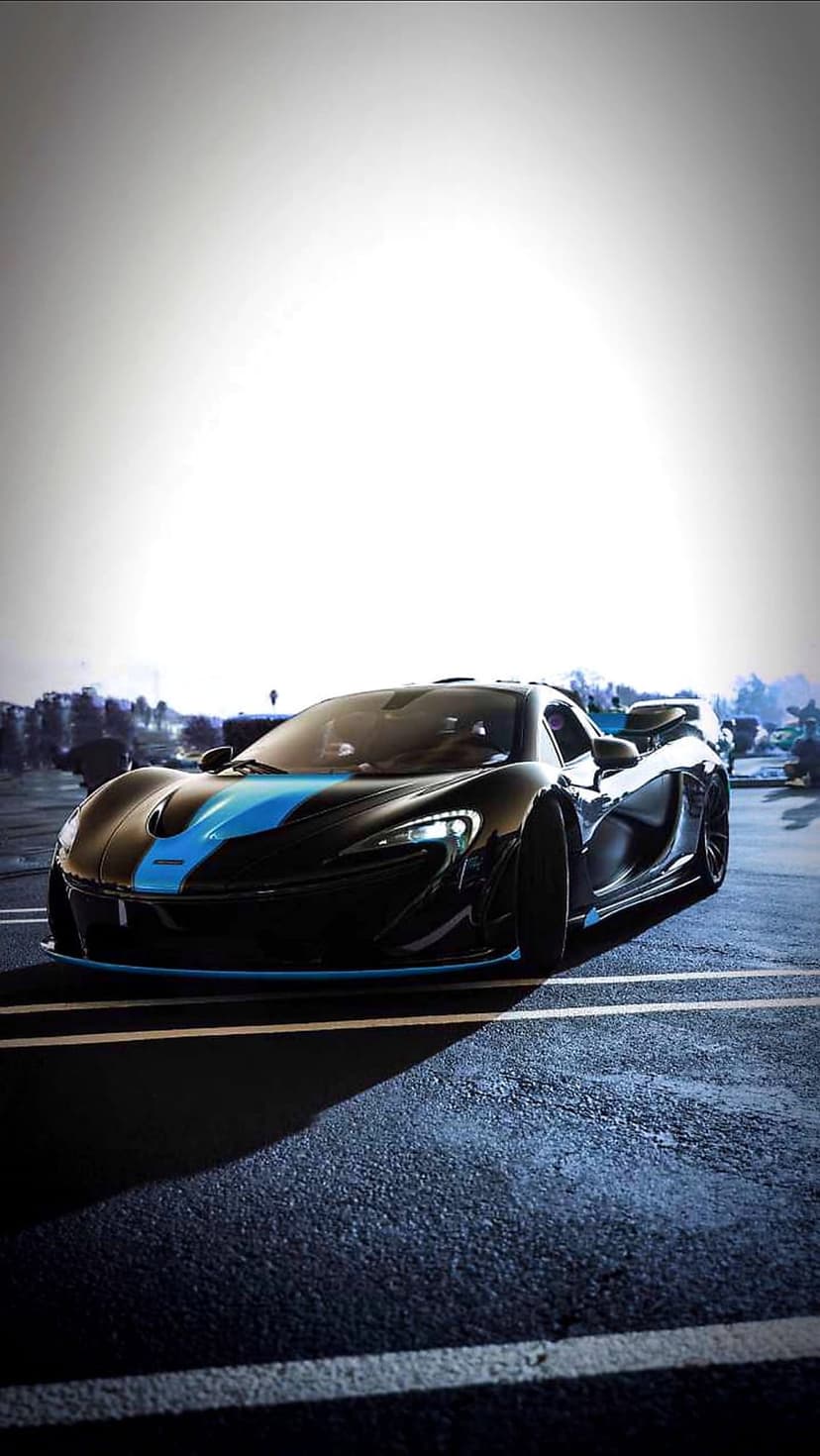 McLaren P1 supercar with a blue racing stripe parked on wet asphalt during an overcast day in an urban setting.