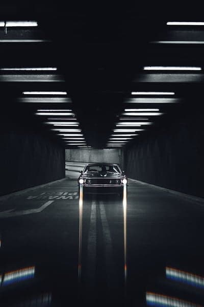 Vintage Black Car Racing Through Dark Tunnel Phone Wallpaper