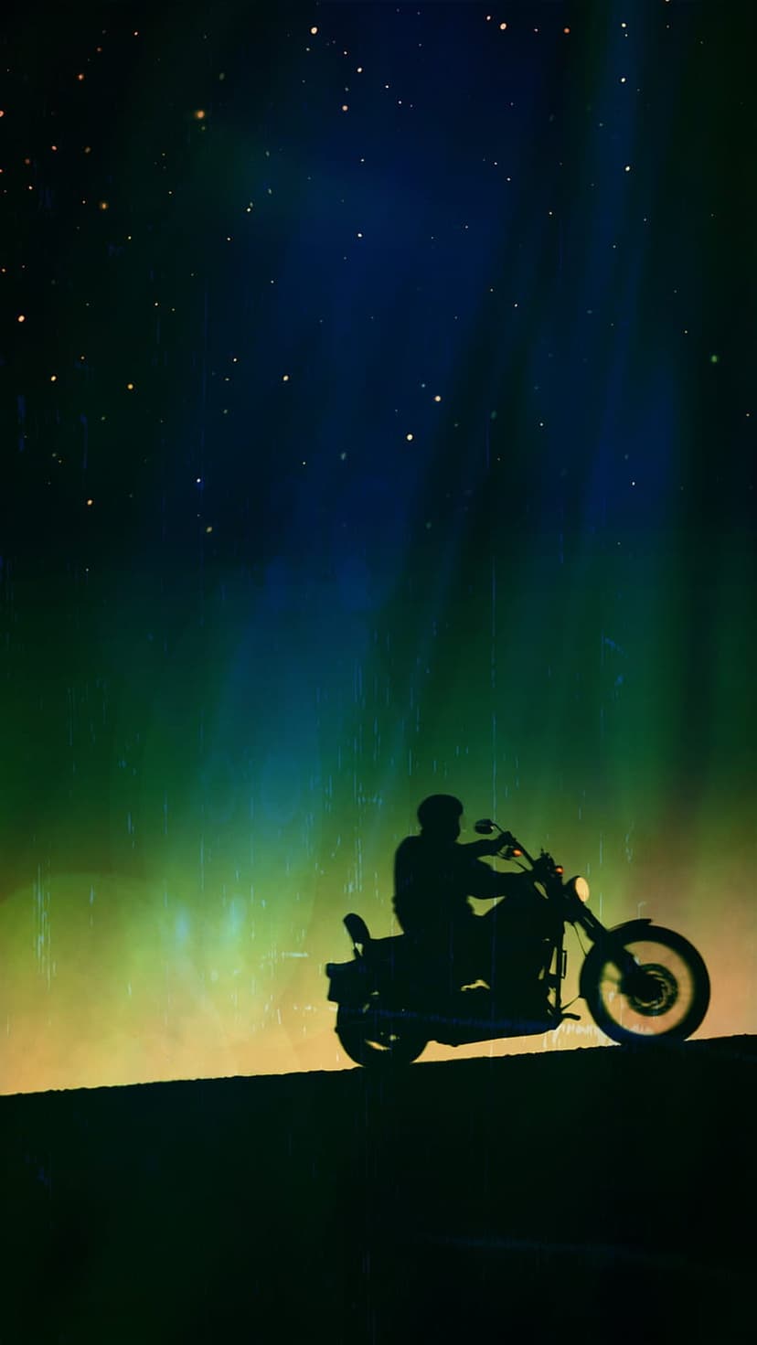 Motorcyclist silhouette stands beneath a starry green and yellow nebula with light rays on a dark night horizon.