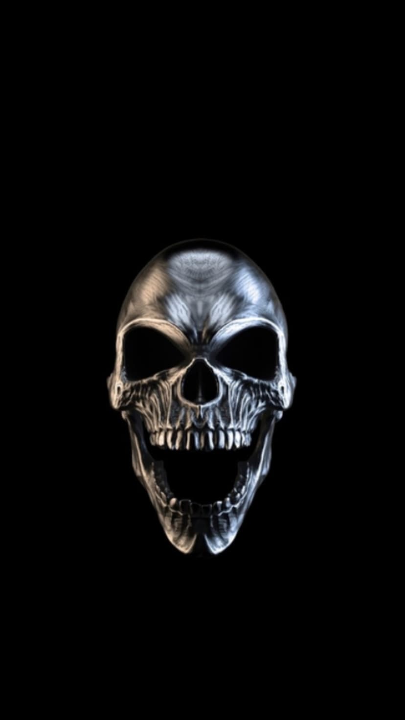 Metallic silver skull with an open mouth and sharp teeth positioned against a solid black background.