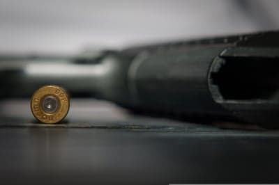 Close-up of bullet casing and firearm