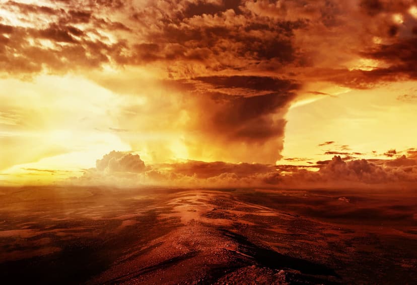 Turbulent orange clouds collide above a desolate red desert path, creating a dramatic and atmospheric vista.