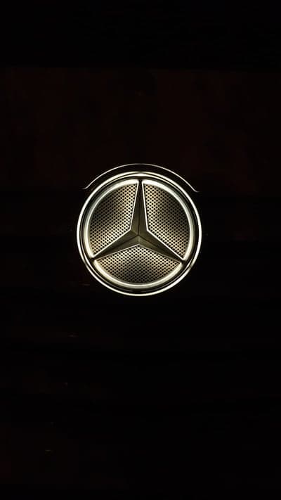 Illuminated Mercedes-Benz Logo on Dark Background