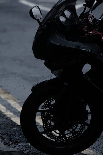 Moody Black Sportbike Wheel on Wet Asphalt Mobile Wallpaper