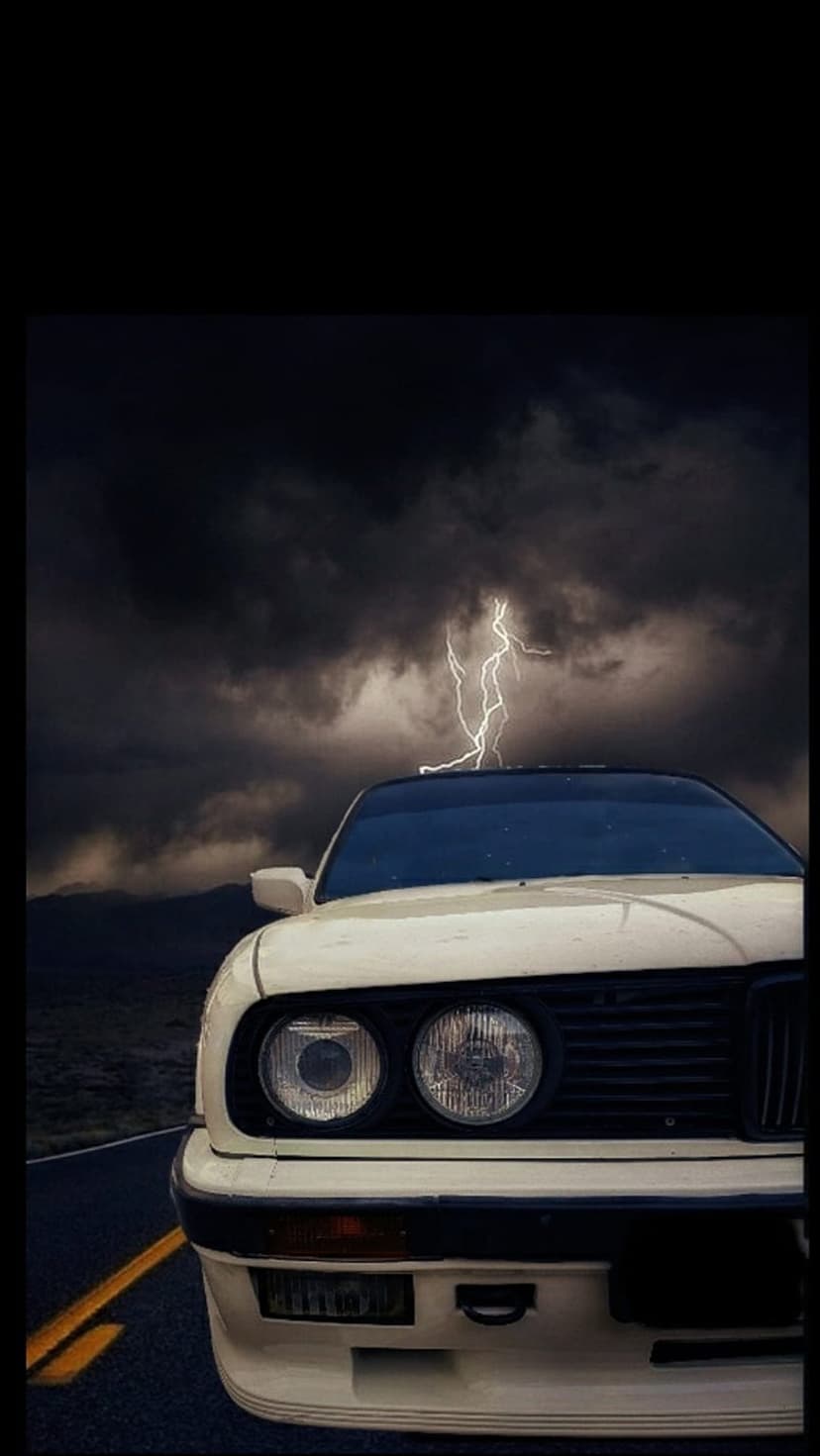White vintage car on a dark road with a massive lightning bolt striking a stormy purple and blue sky.
