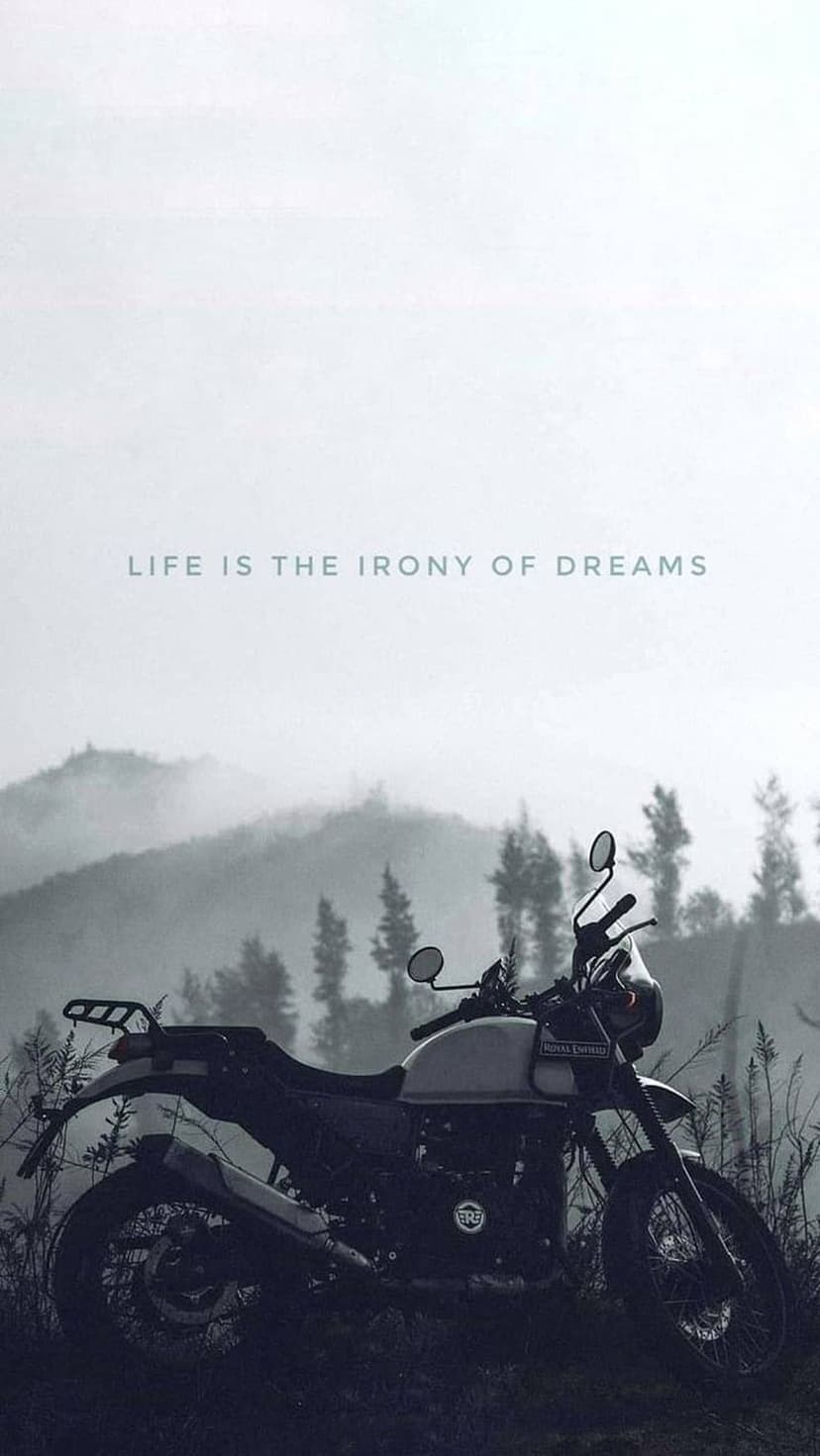 Vintage motorcycle silhouette on a misty mountain ridge with text overlaid against a pale foggy sky.