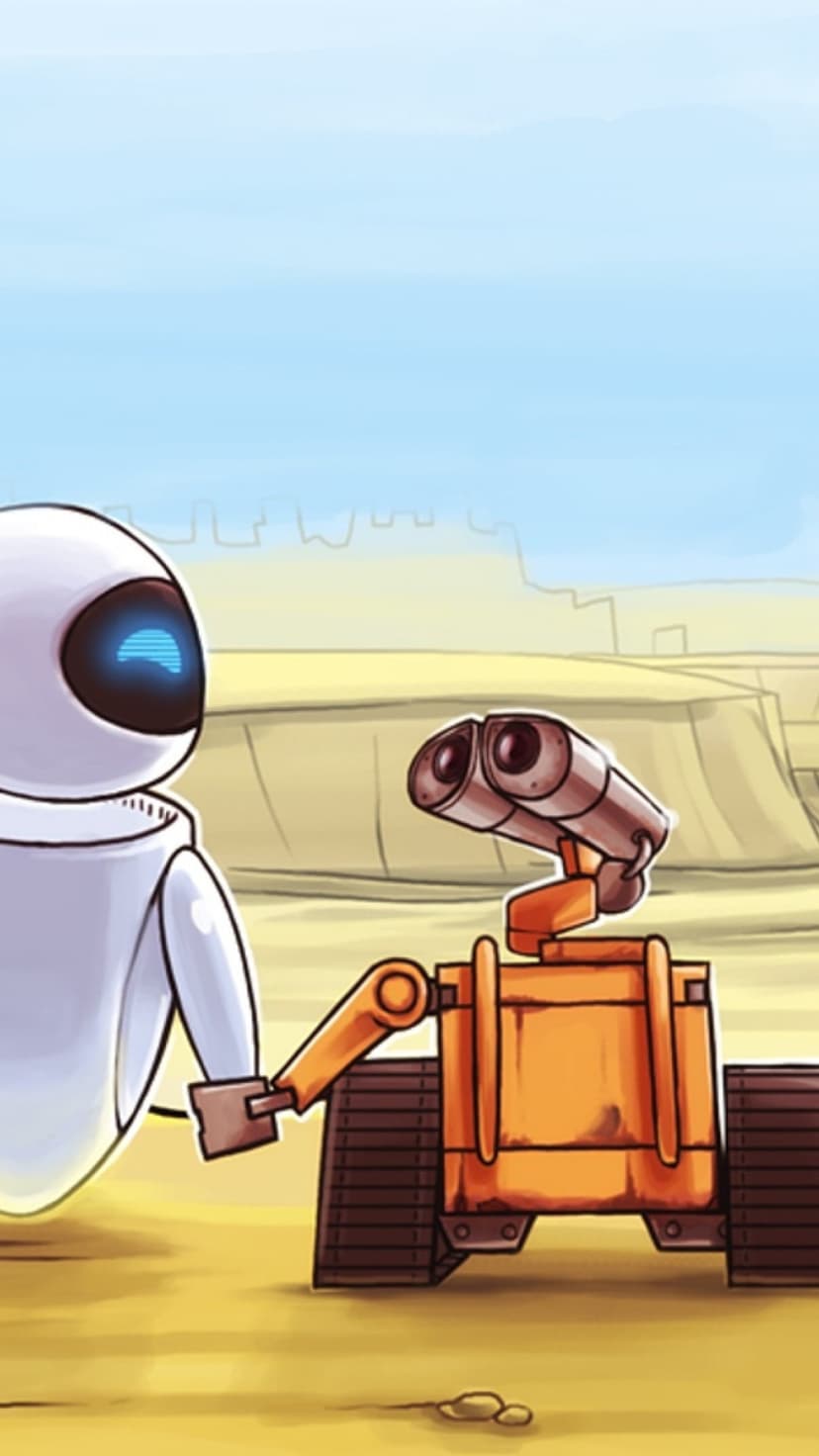 WALL-E reaches toward EVE in a vast sandy wasteland with a hazy, ruined city visible in the distant background.
