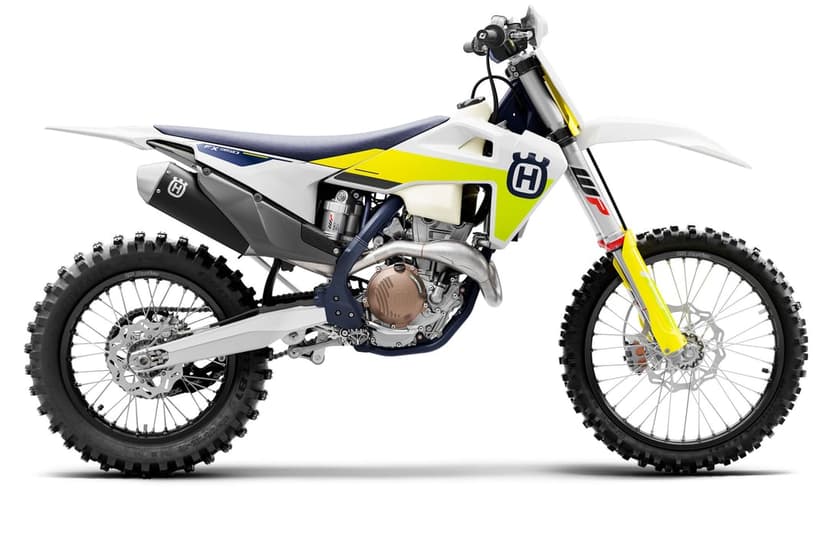 Husqvarna FX 350 dirt bike side view with white and yellow bodywork, knobby tires, and bronze engine components.