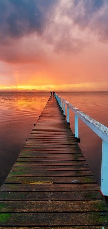 Vivid Sunset over a Tranquil Ocean Pier