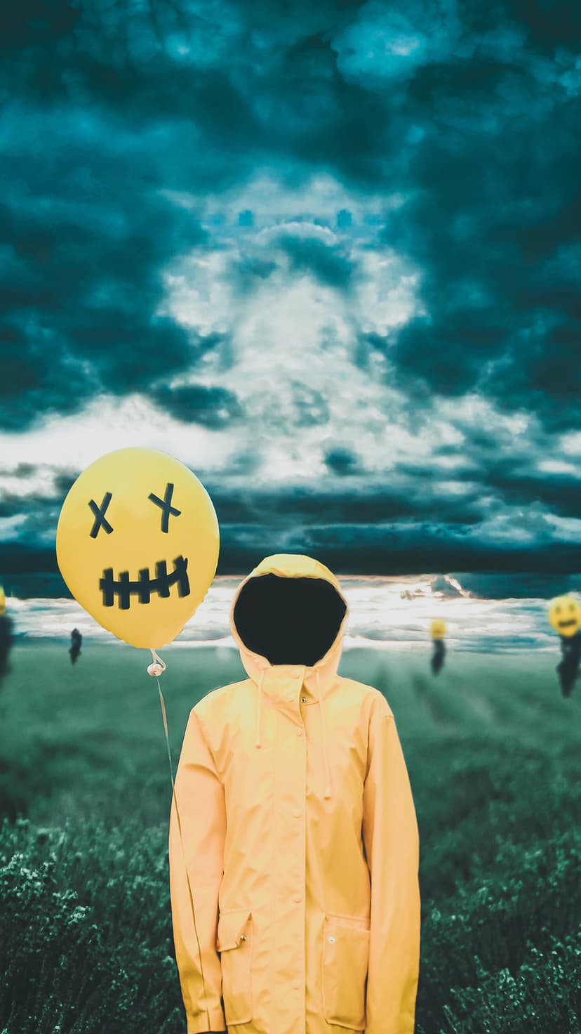 Person in a yellow raincoat holds a dead-smiley balloon in a dark, misty field under a turbulent storm sky.