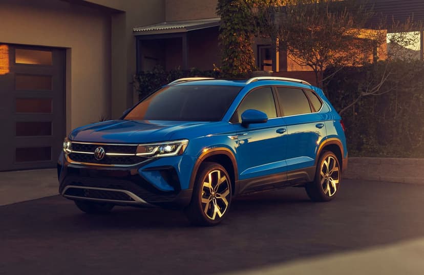 Blue Volkswagen SUV parked in a driveway at sunset with warm golden light reflecting off the metallic paint.