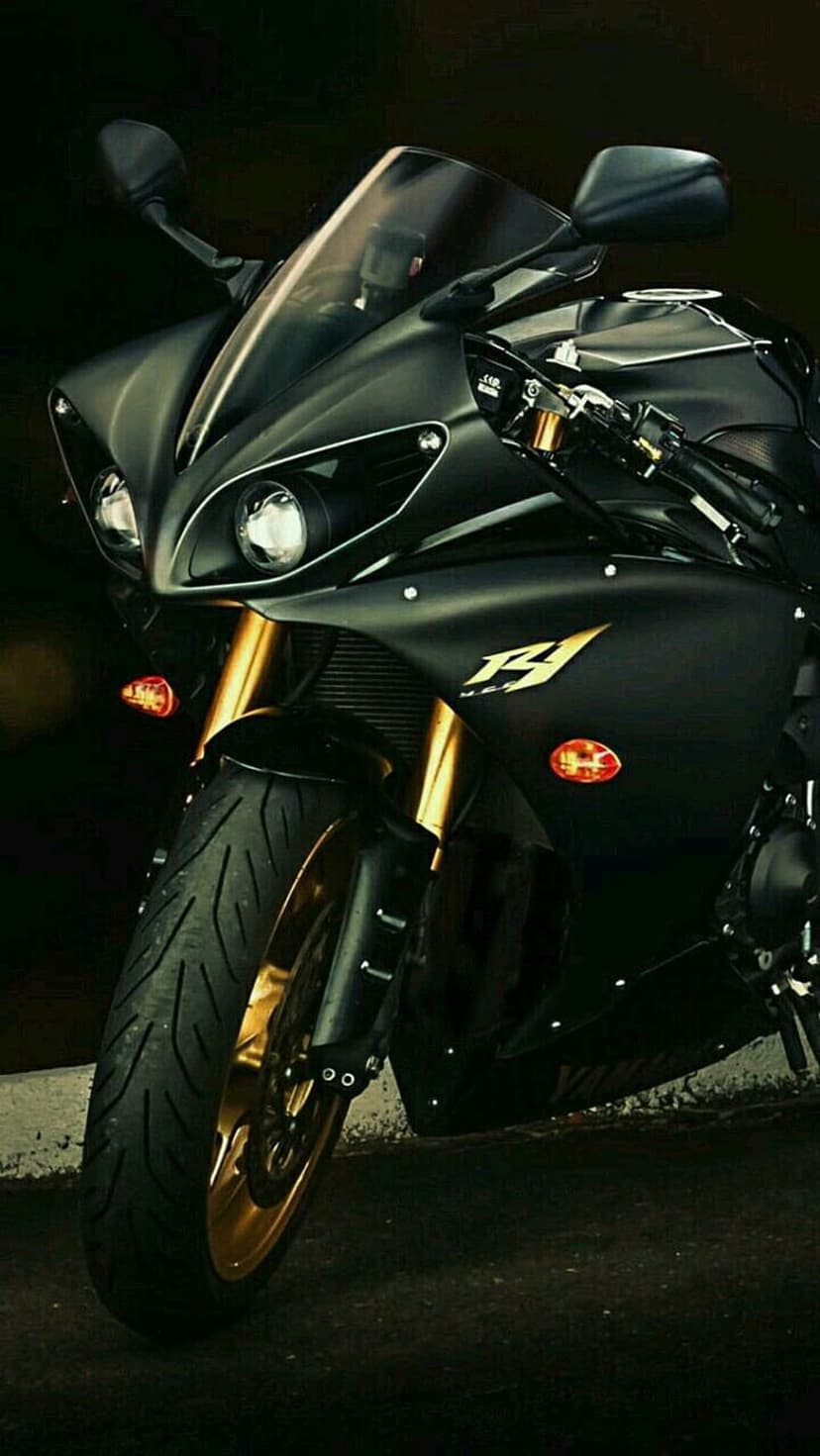 Yamaha R1 motorcycle features gold front forks and dual headlights against a dark, minimalist background.