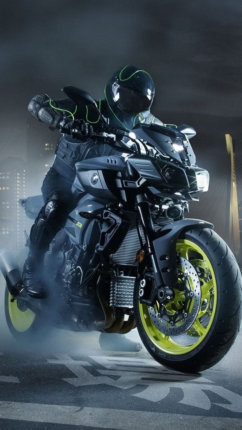Yamaha motorcycle rider with glowing yellow rims maneuvers through a smoky urban street at night with neon bokeh.