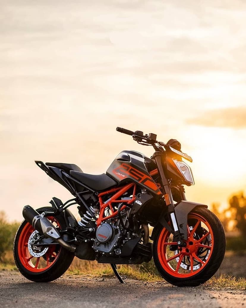 KTM 390 Duke motorcycle with orange wheels parked during a golden hour sunset, highlighting the trellis frame.