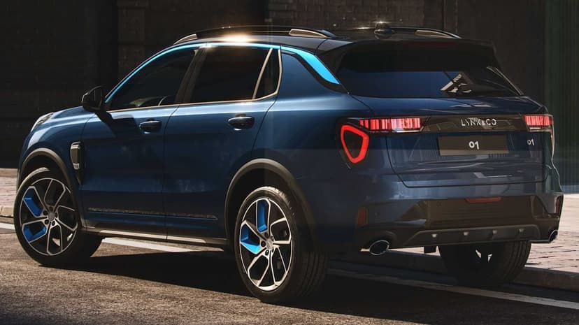 Rear view of a dark blue SUV with LED lights and blue wheel accents on a city street at night.