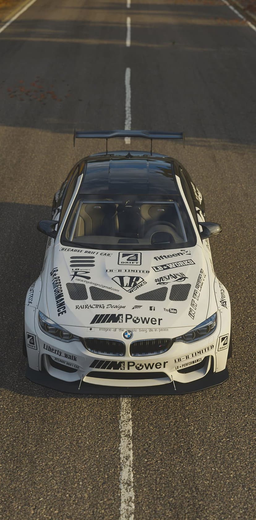 White BMW M4 drift car with Liberty Walk decals and a widebody kit parked on a paved road with white lines.