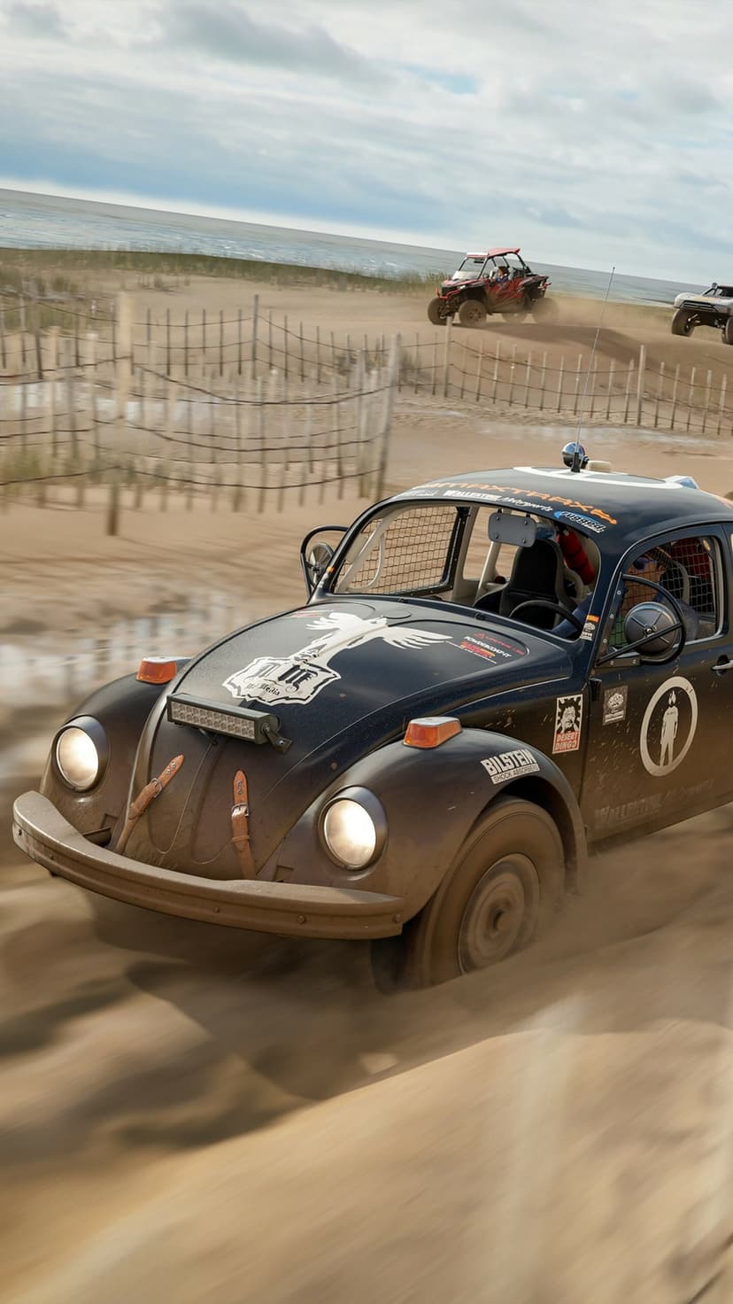 Black off-road Baja Bug racing through sand on a beach track with motion blur and other racers in distance.