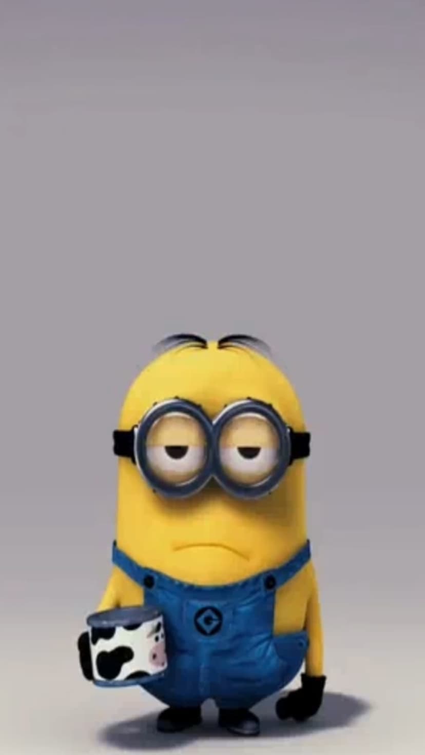Yellow Minion wearing blue overalls and silver goggles holds a cow-print mug with a tired expression.