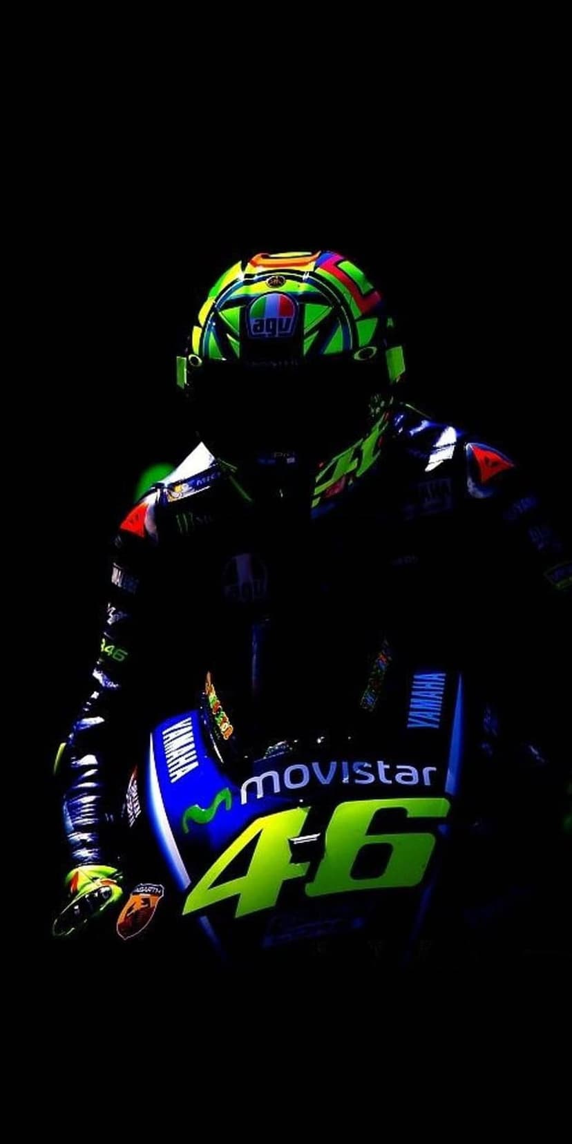 Valentino Rossi AGV helmet and Movistar Yamaha motorcycle with number 46 displayed on a dark, moody background.