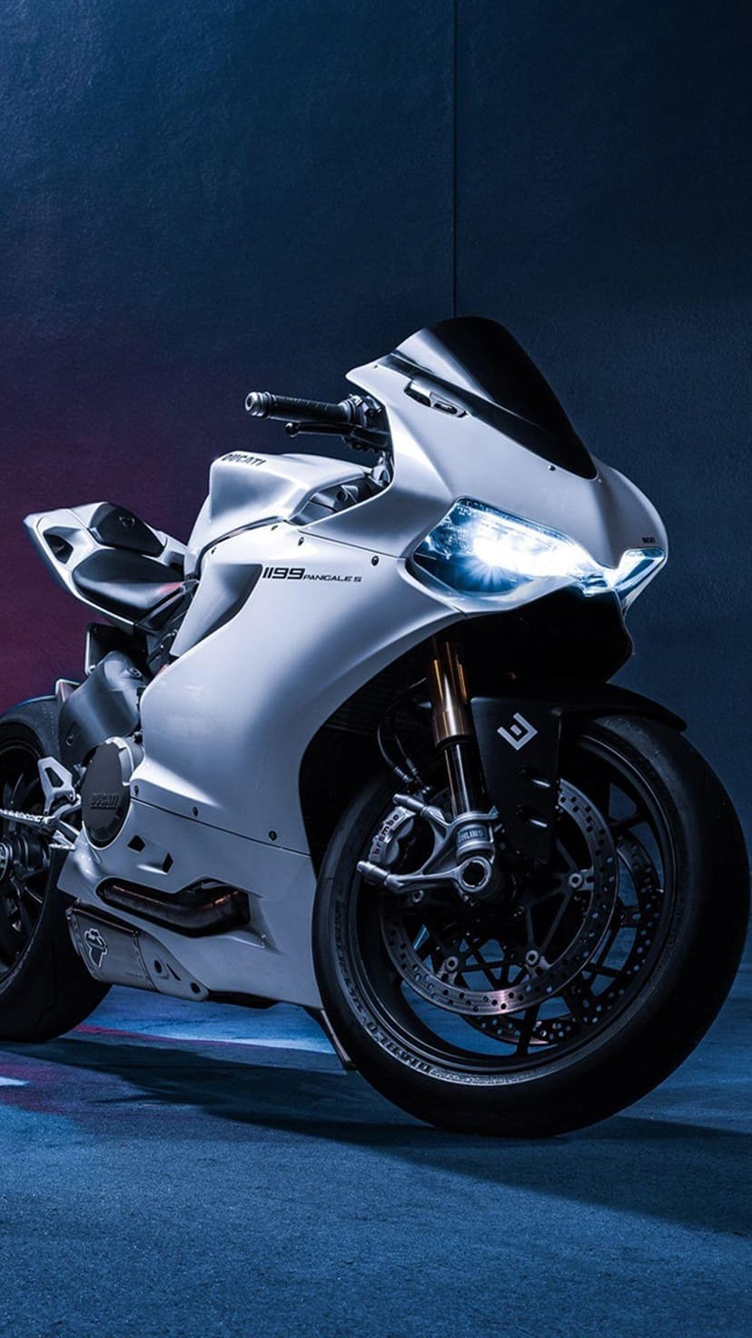 Ducati 1199 Panigale front fairing and LED headlights against a dark textured wall in a portrait shot.