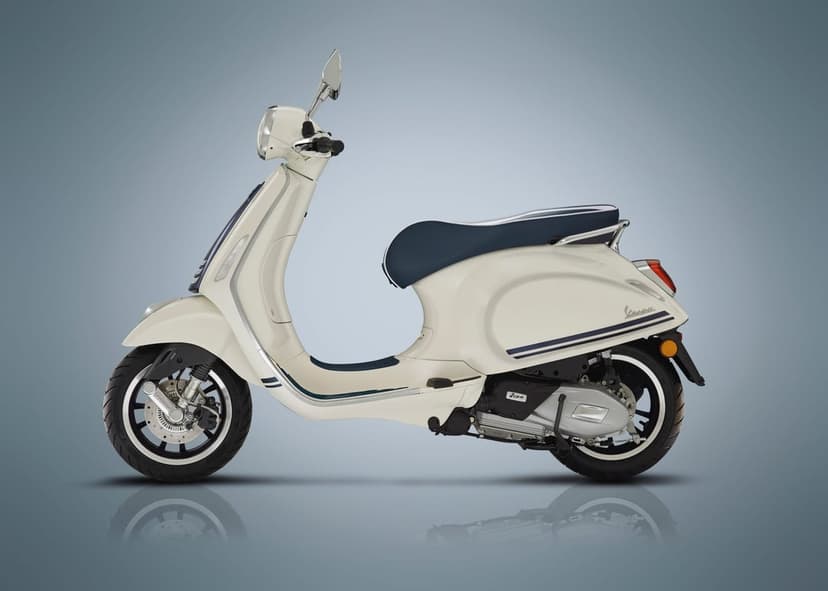 Side view of a cream Vespa scooter with a blue seat and navy racing stripes on a gray gradient background.