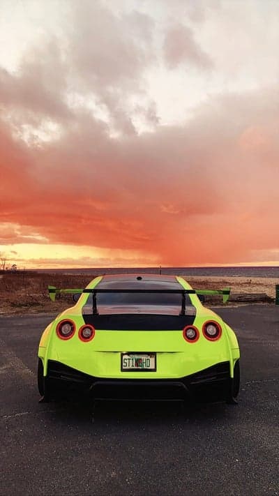 Acid Green Nissan GT-R Under Fiery Sunset Mobile Screen