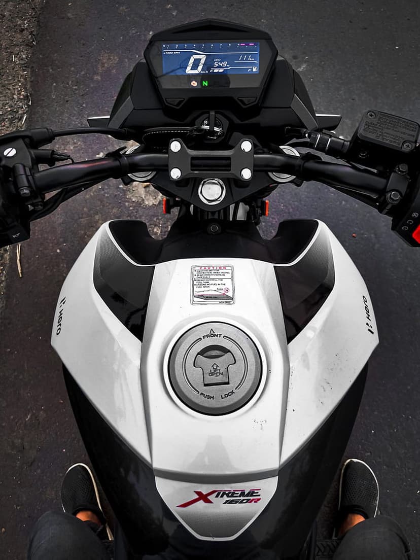 Hero Xtreme 160R digital dashboard, handlebars, and black fuel tank captured from a first-person perspective.
